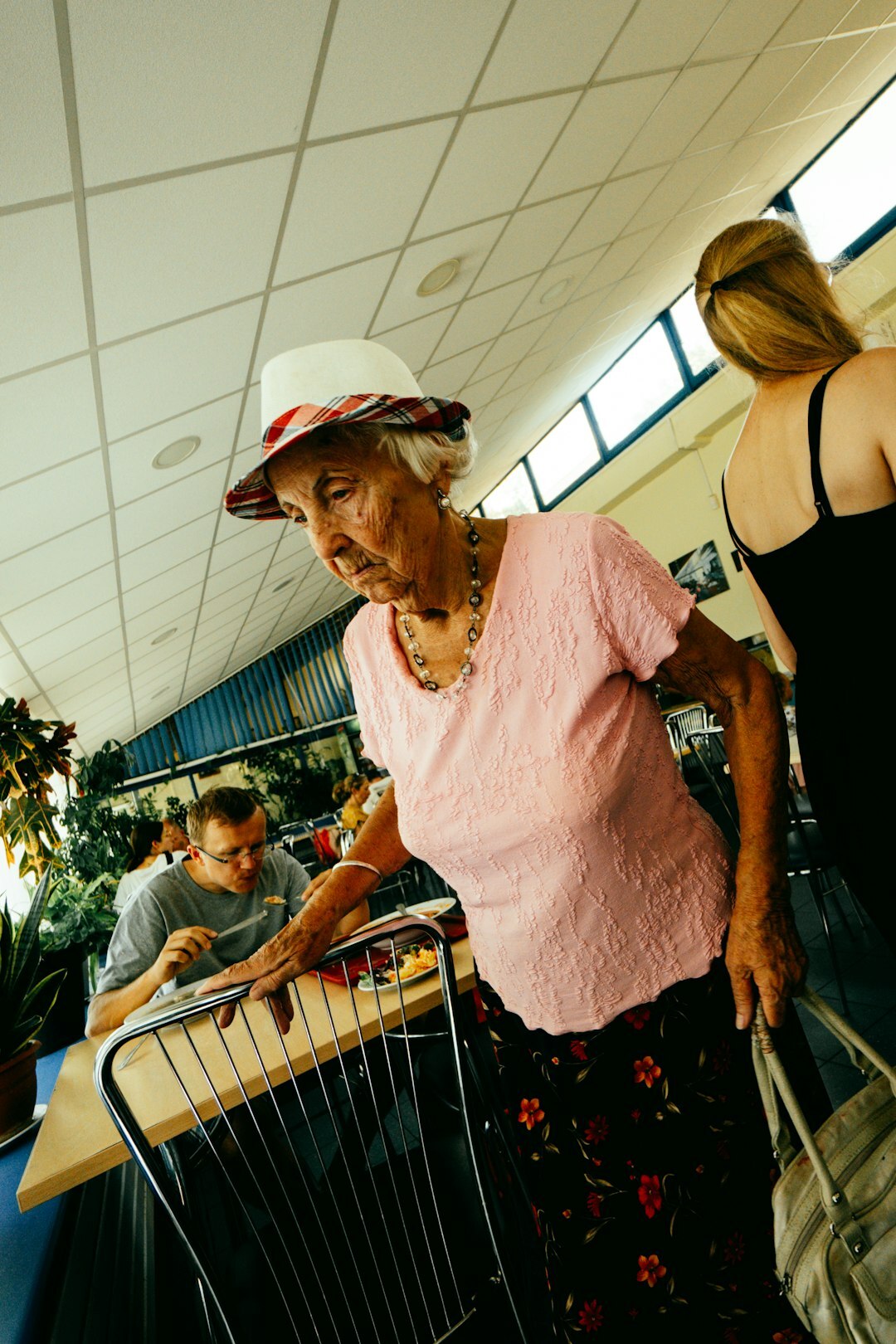Senior woman signing a membership form with a staff member